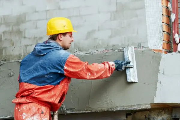 Stucco contractor fixing exterior stucco wall