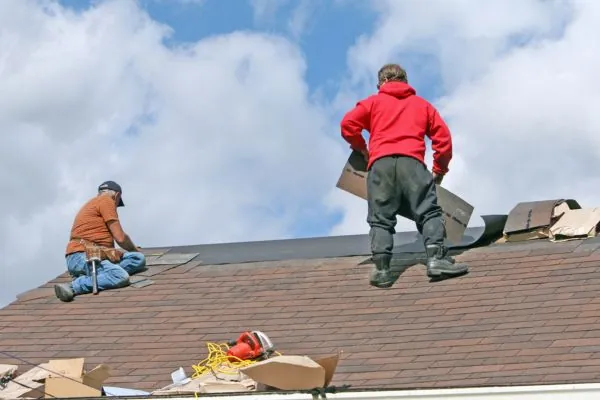 roof contractors replacing old roof shingles in residential house 