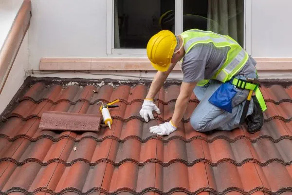 professional roof contractor inspecting roof tile leak